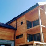 L'assistance à maitrise d'ouvrage vous aide à faire les bons choix : Façade en bardage mélèze contemporain avec œil de bœuf et zingueries anthracites. Boileau Sébastien