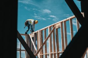 Construire en 2025 - Charpentier effectuant le levage de mur ossature bois